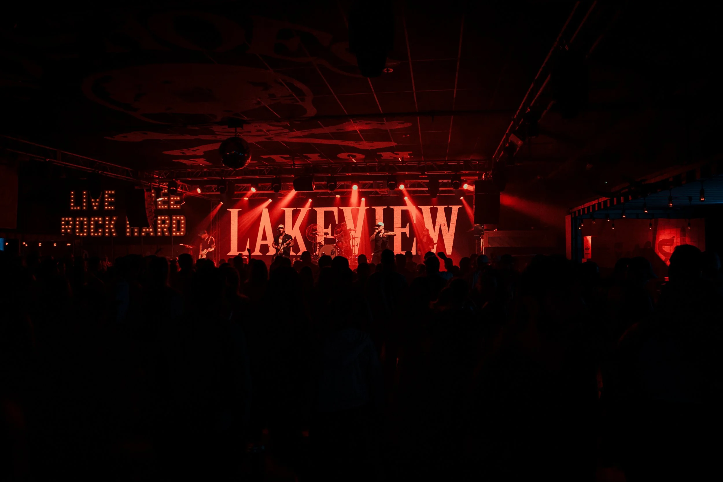 Lakeview performing live in front of a crowd under red lights